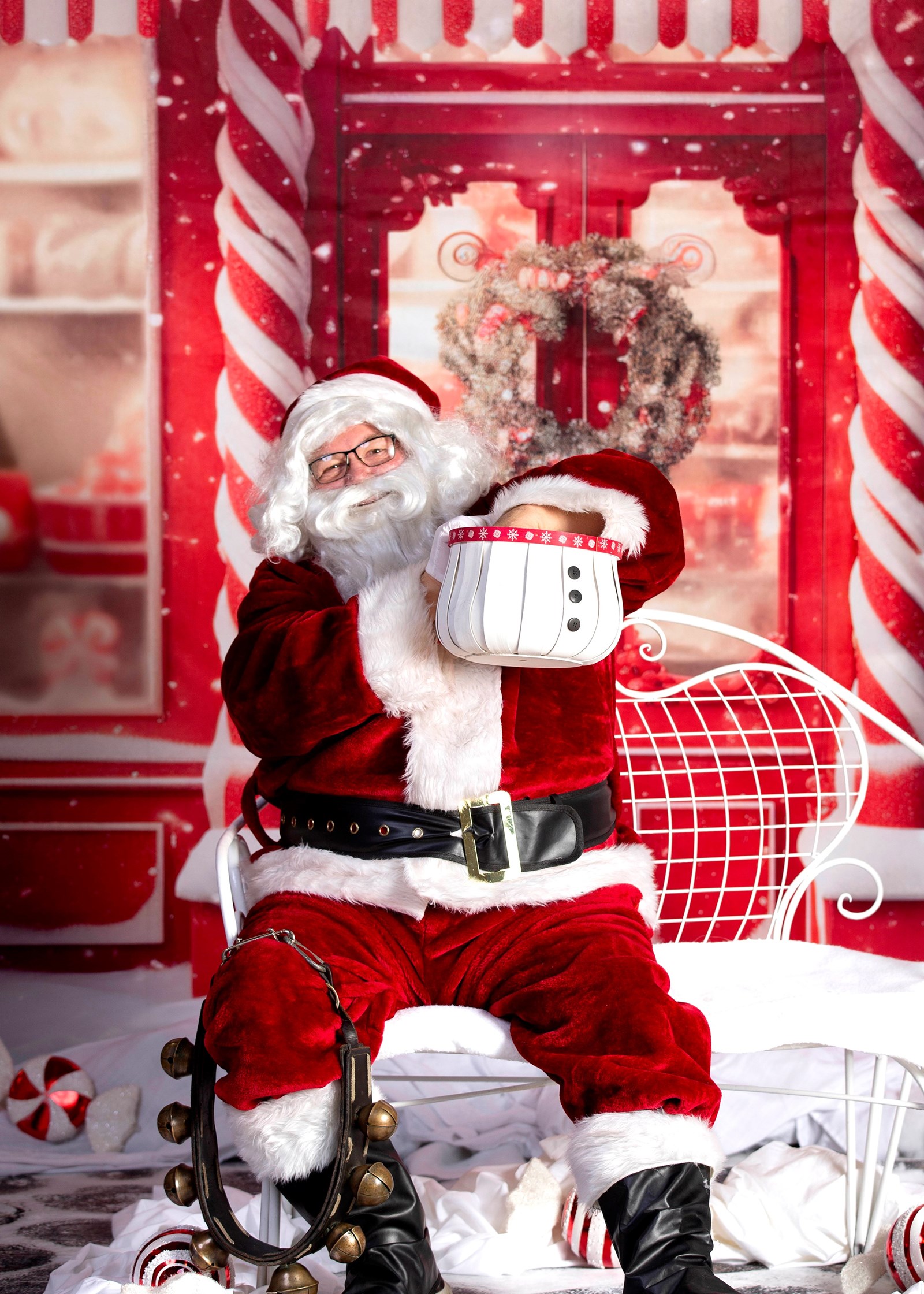 Sant sitting in his chair reaching into a snowman basket to draw a prize ticket