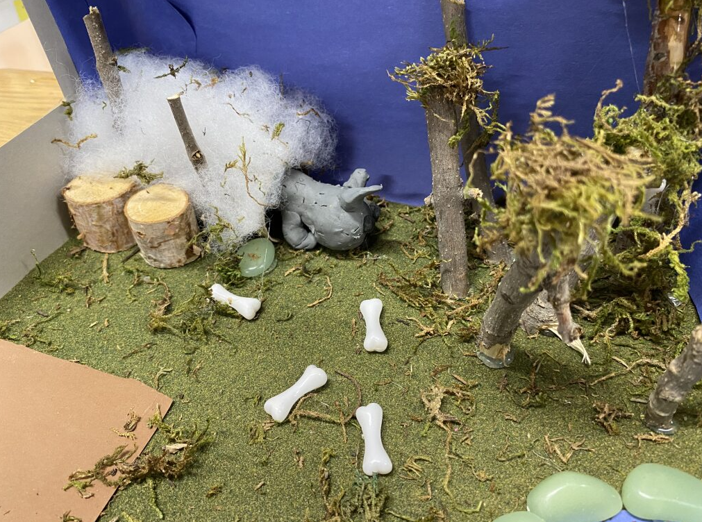 Clay wolf in it's habitat - field with trees and some snow