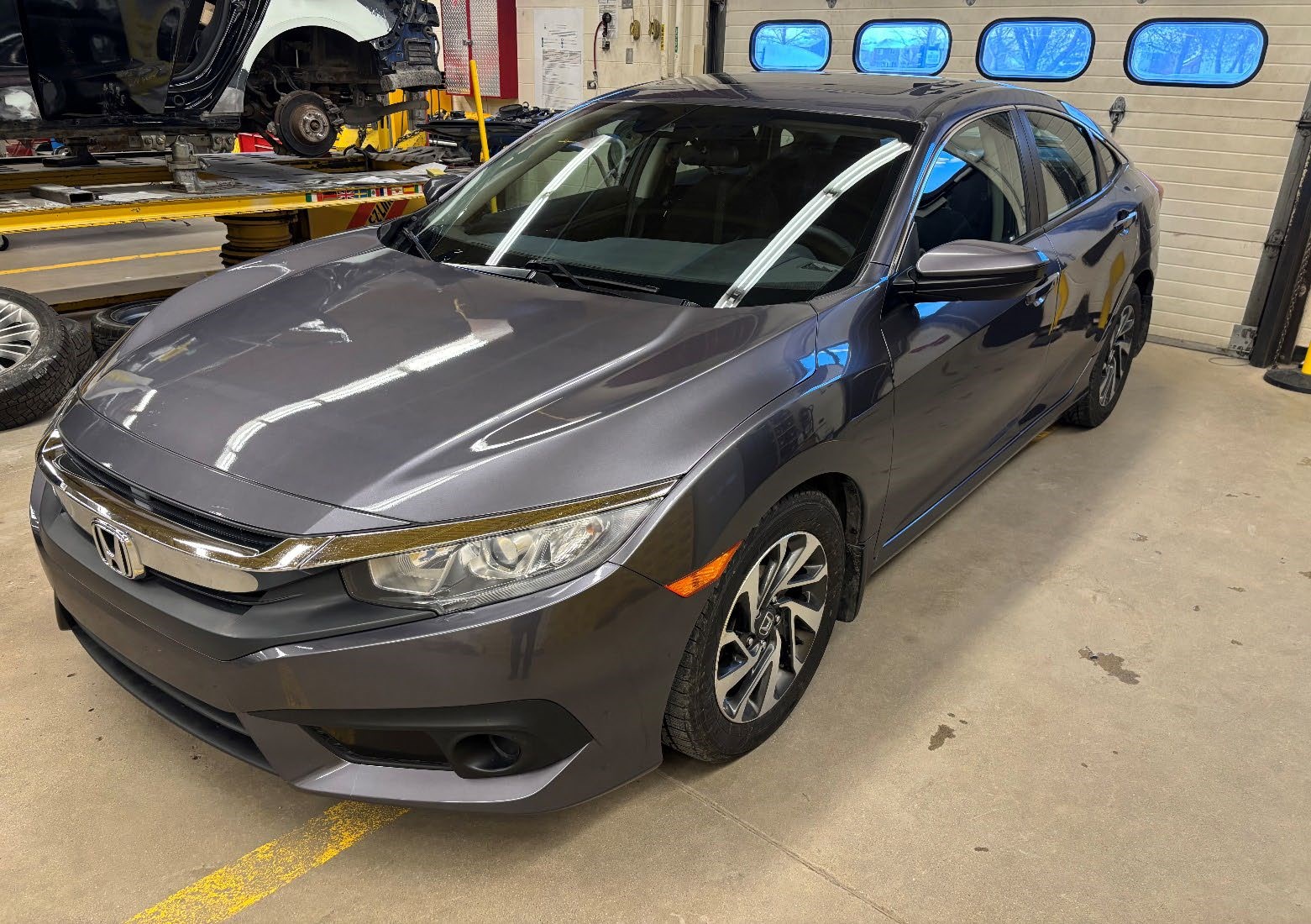 Photograph of a 2014 Honda Civic EX (Reconditioned) parked inside an automotive workshop.