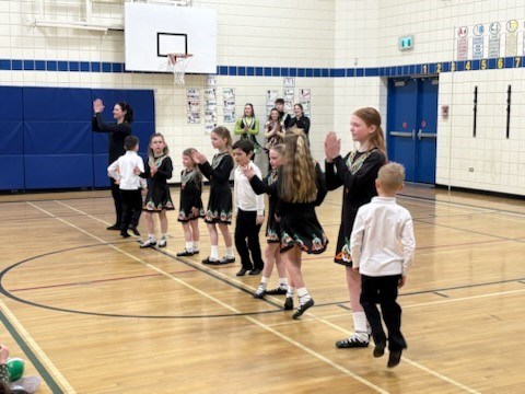 McConnel Irish Dancers perform in a school gymnasium. There are approximately 12 dancers